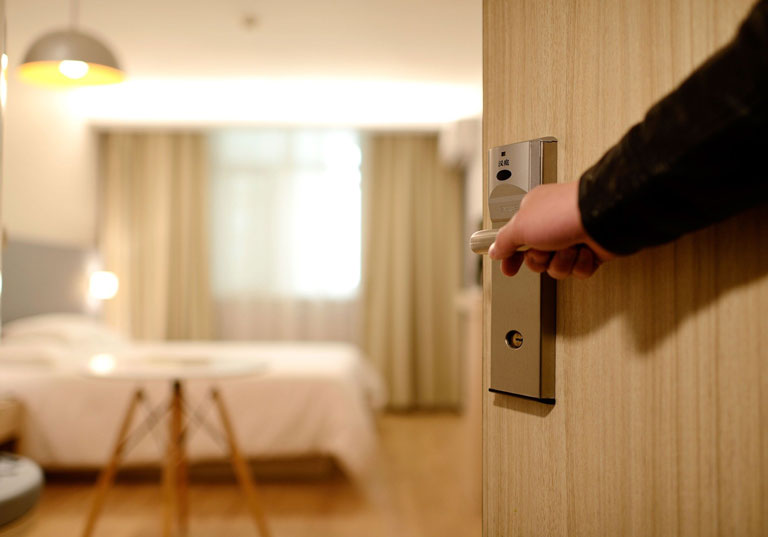 Türe zum Hotelzimmer wird mit einer Hand geöffnet