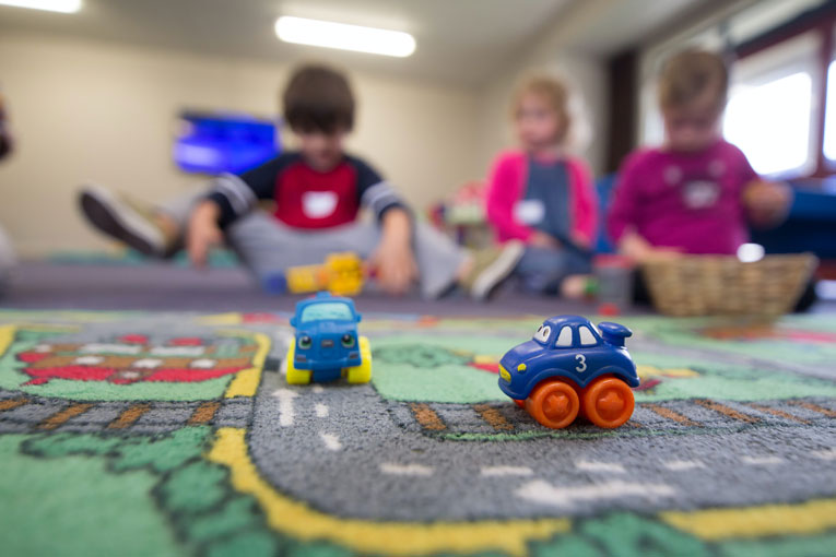 Kinder spielen mit Spielzeugautos im Kindergarten